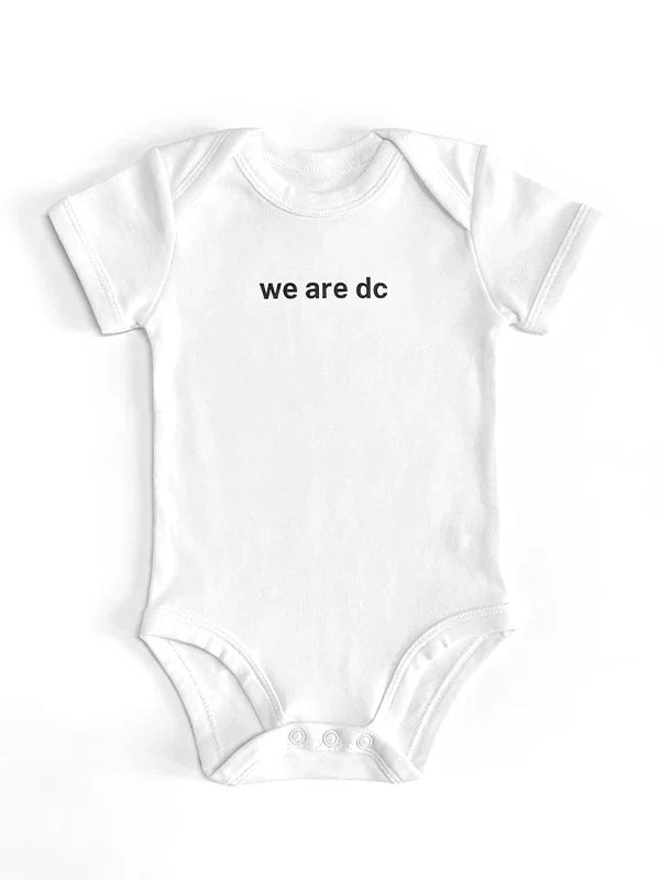 dc Baby Strampler in weiß mit dc Slogan