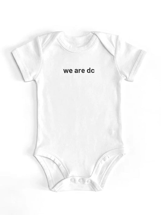 dc Baby Strampler in weiß mit dc Slogan